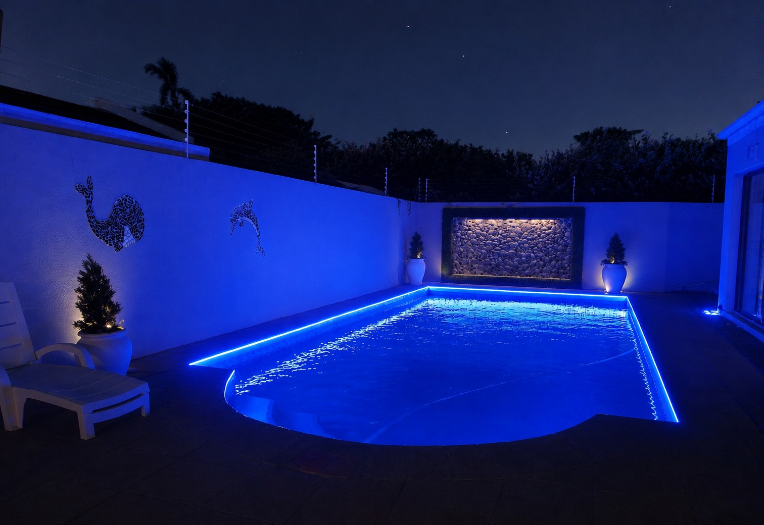 Private pool at night lit with blue LED ambience lighting